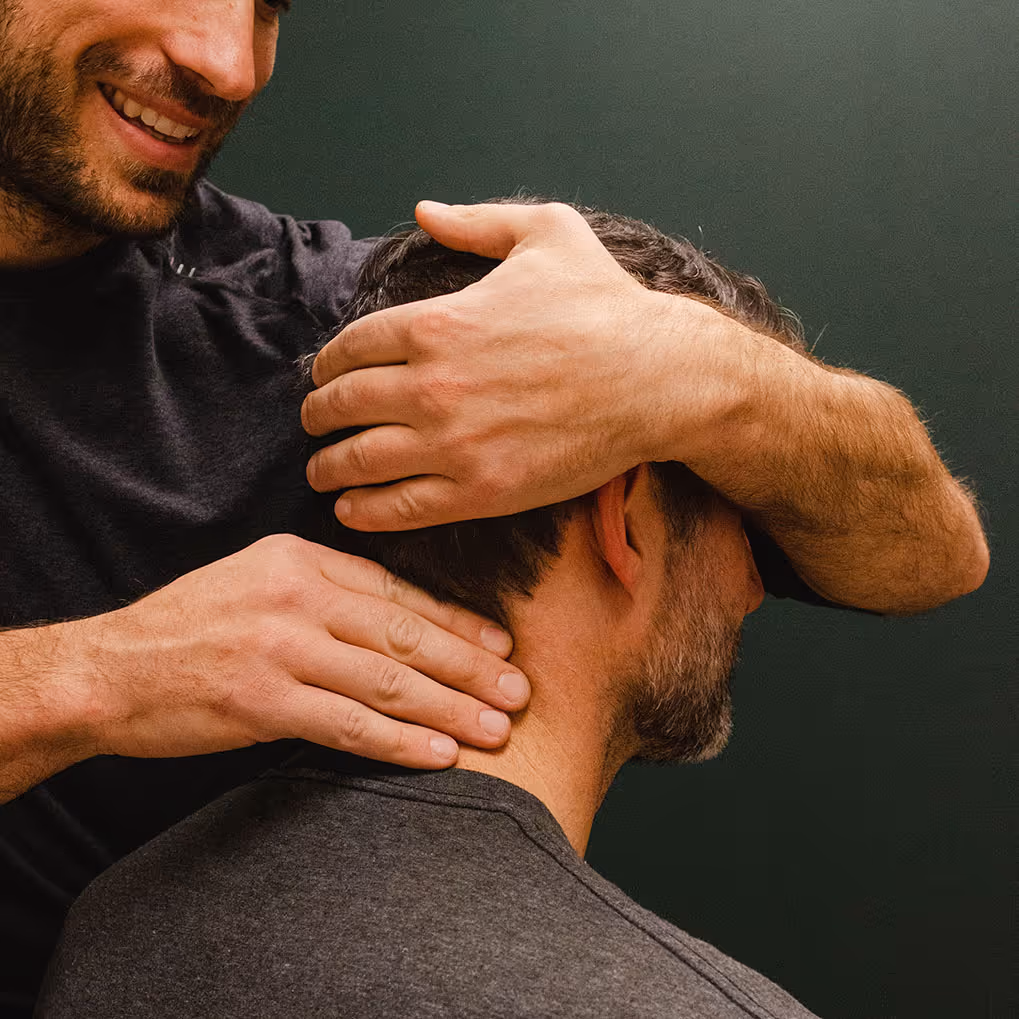 Un homme reçoit un massage expert du cou par des mains expertes sur son cou et son cuir chevelu.