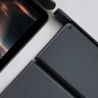 Close-up of a dark modern electronic device with a sleek matte finish and a partial screen visible at the corner.
