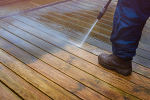 Powerwasher cleaning wood porch