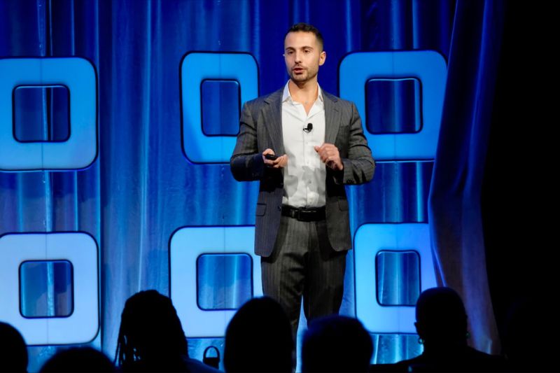 Michael Restiano speaking on stage at a tech conference