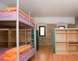 Habitacions compartides de la casa de colònies amb lliteres, armaris i espai per a grups.