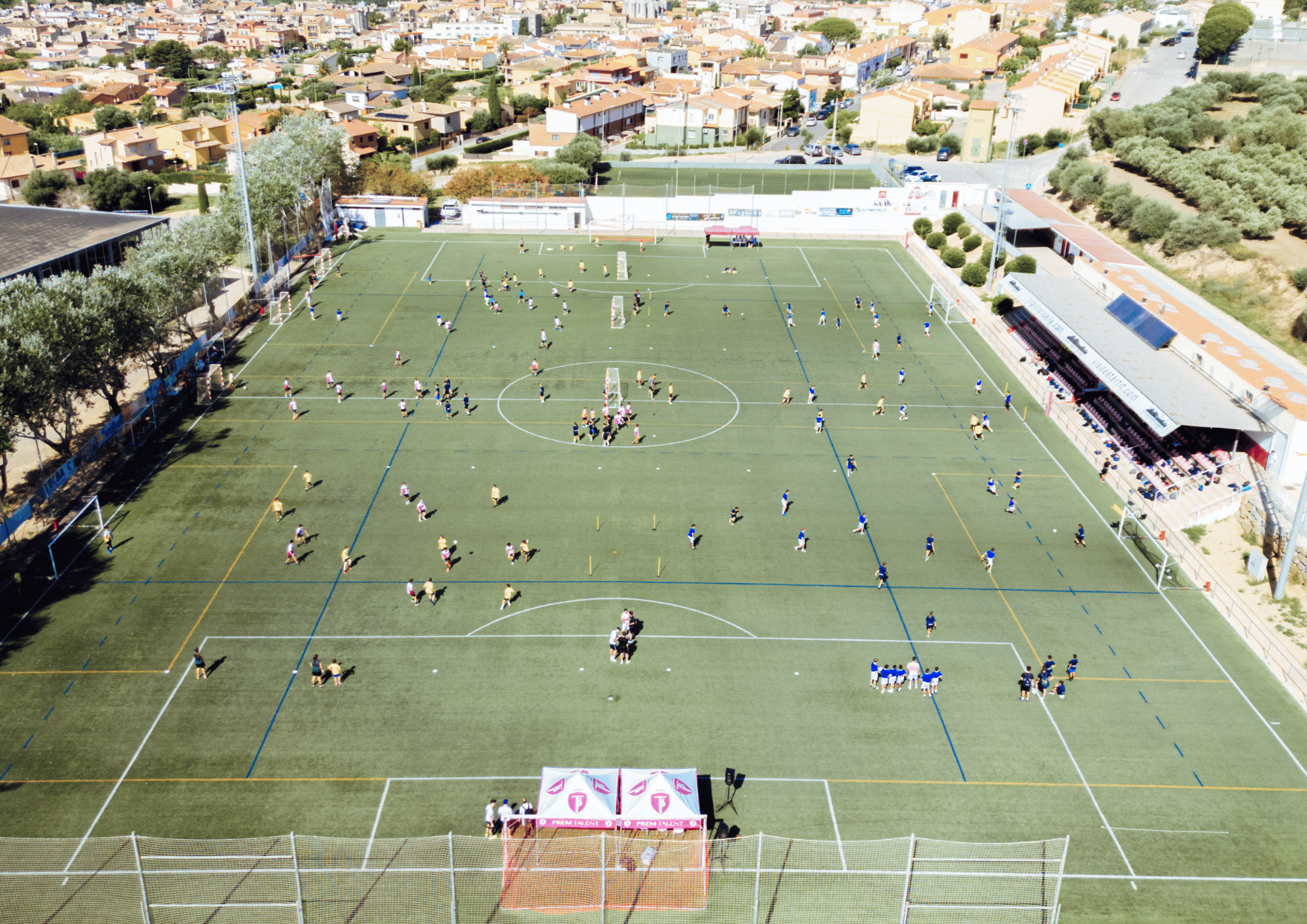 Vista aèria del camp de futbol municipal de Torroella de Montgrí ple de jugadors entrenant.