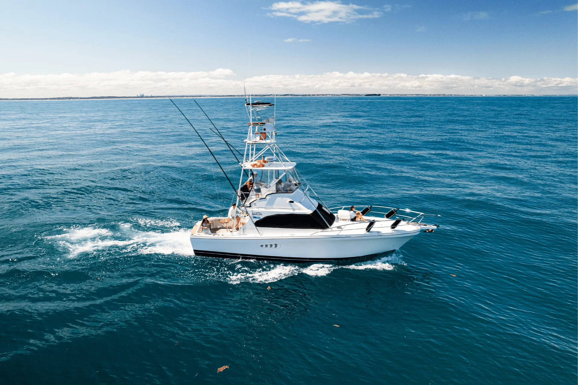 Game Time running across deep blue water with guests on the bow
