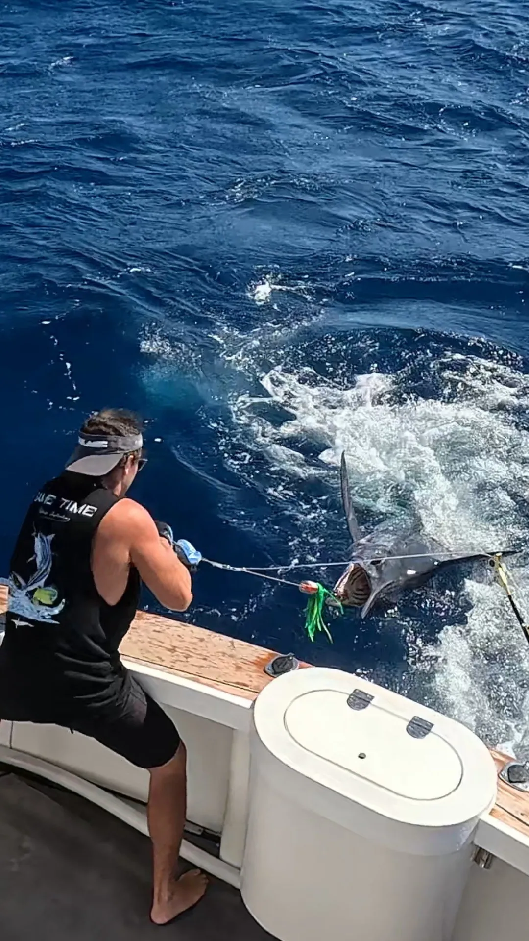 Angler at the transom with a billfish on the leader with Game Time Charters