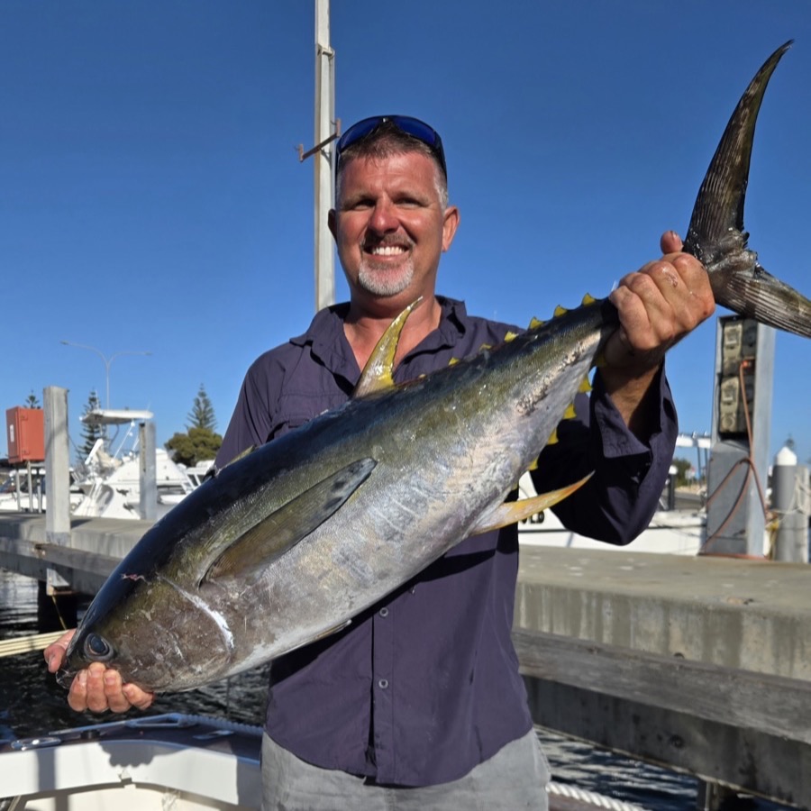 Angler holding a yellowfin tuna caught on a Game Time Charters game fishing charter