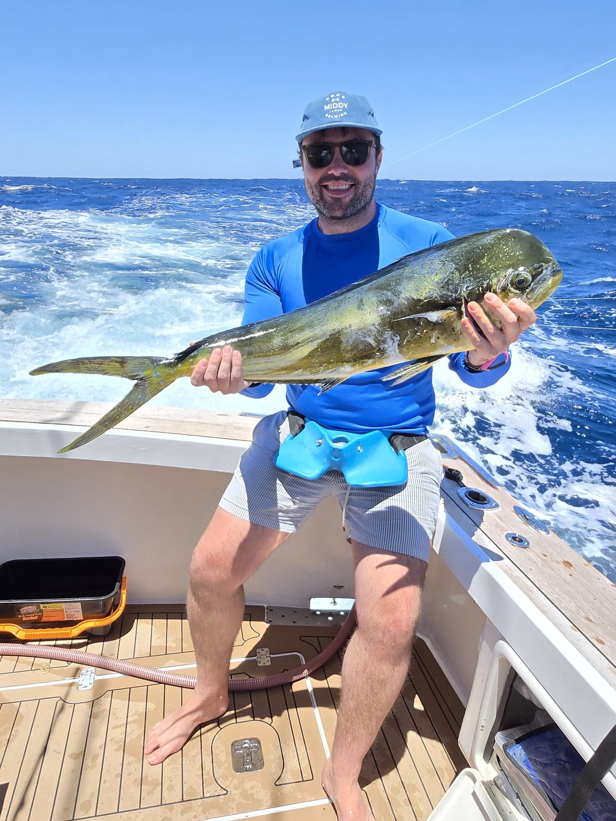 Angler holding a mahi mahi caught offshore on a Game Time Charters game fishing charter