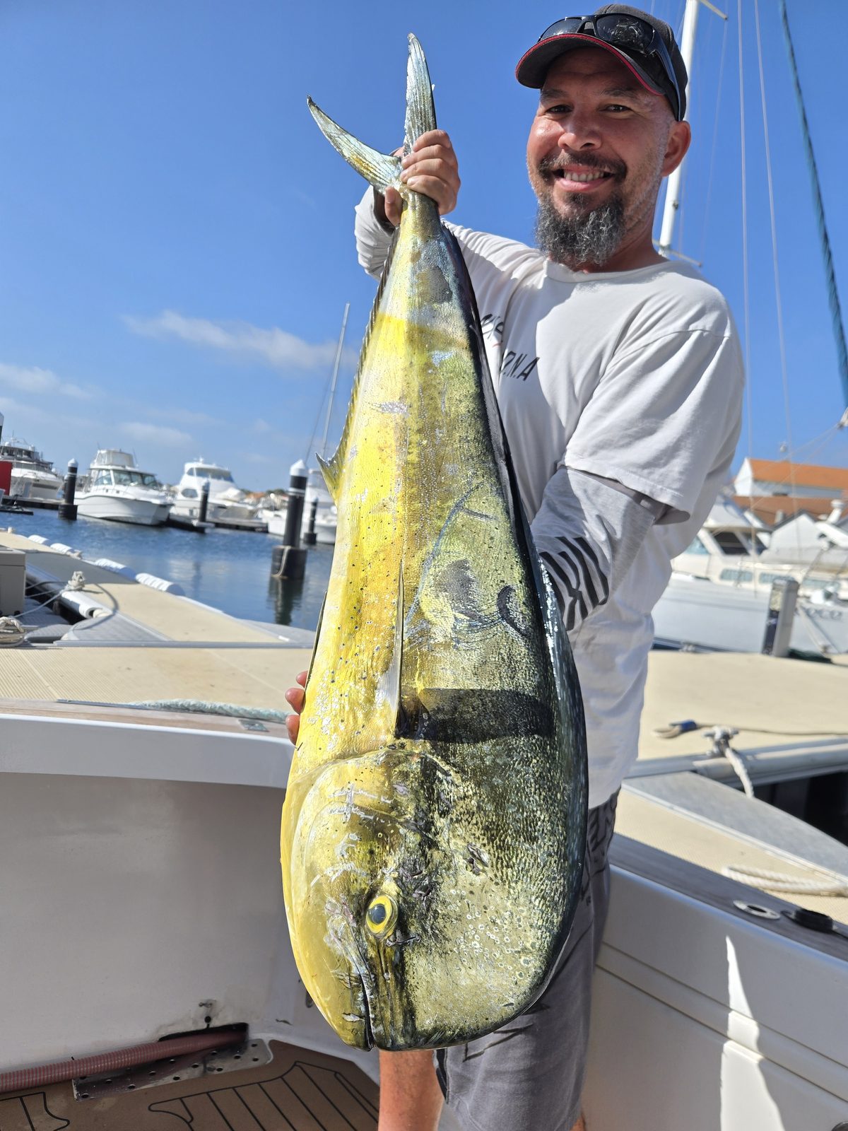 Angler holding a large mahi mahi back at the marina after a Game Time Charters trip