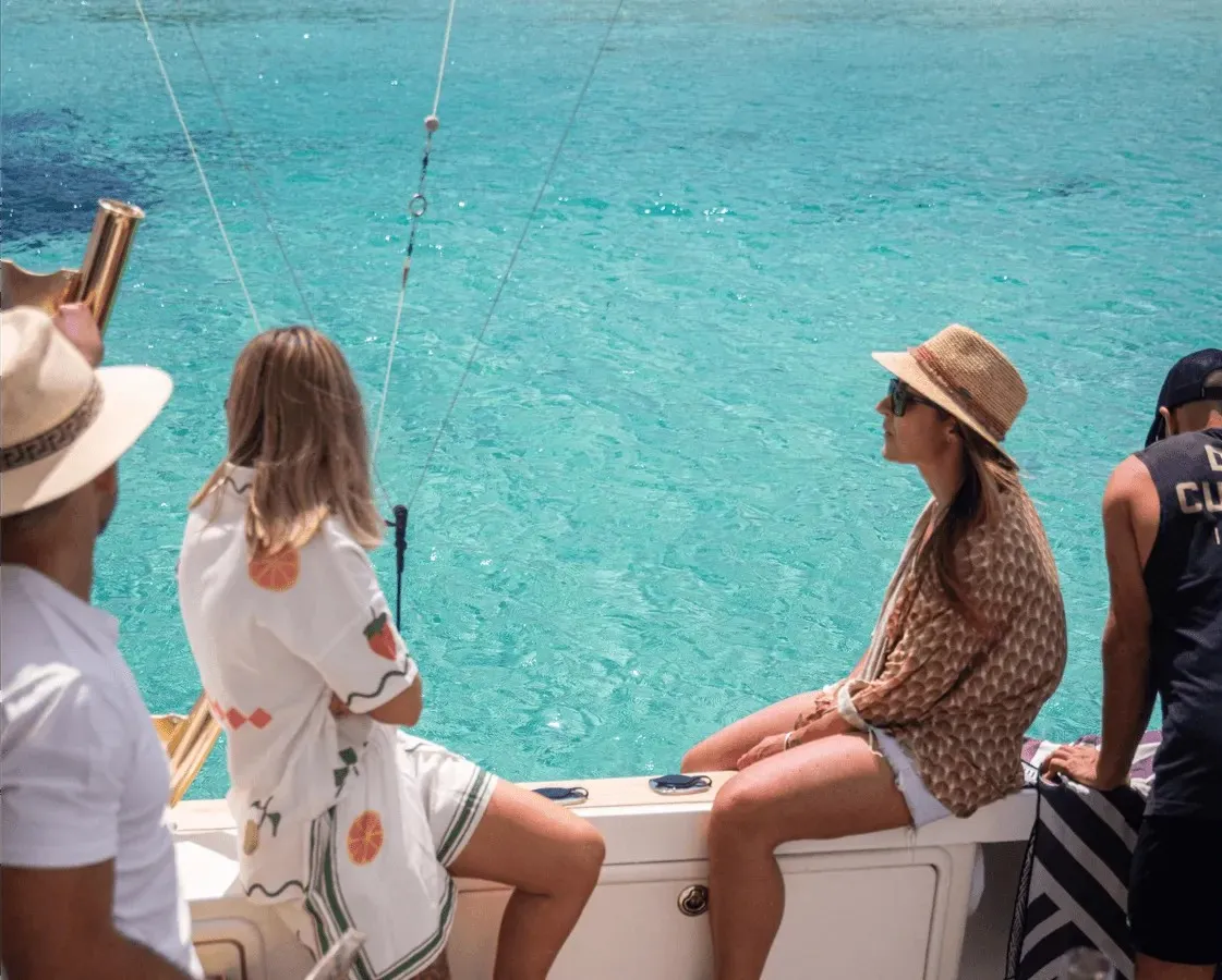 Guests seated along the side of Game Time above turquoise water