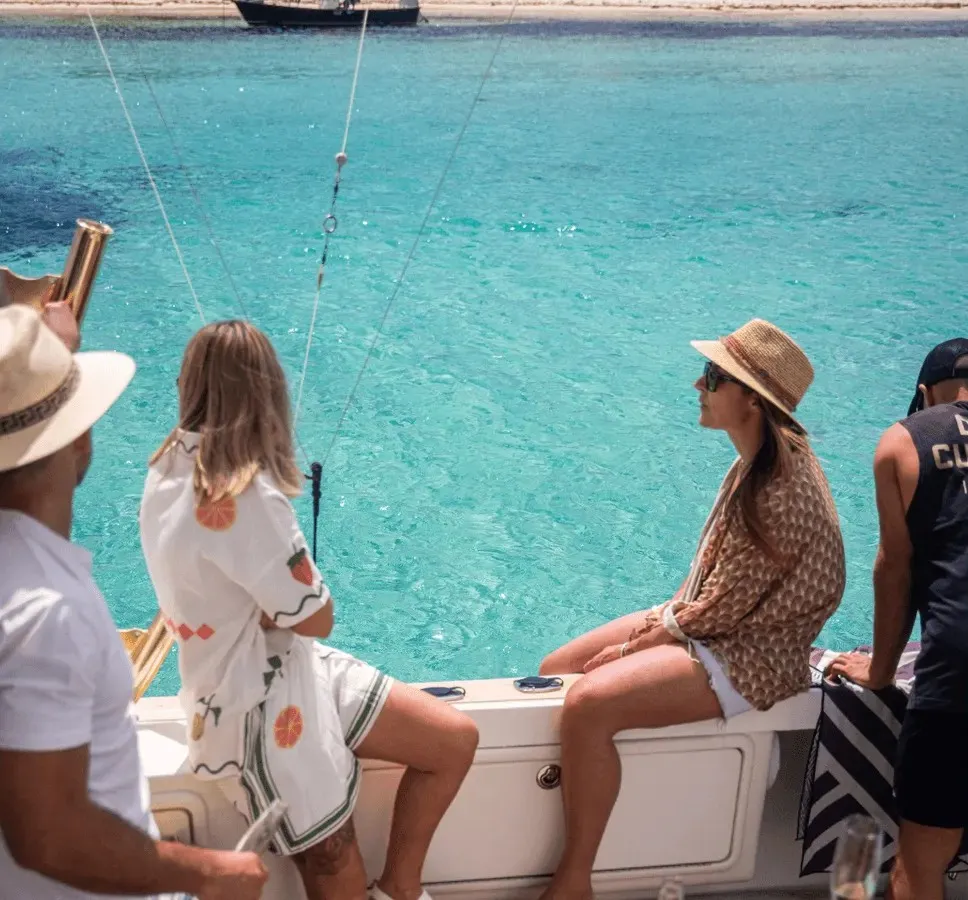 Guests sitting along the side of Game Time looking out over turquoise water