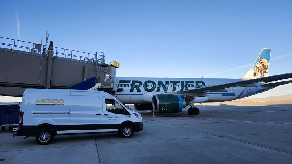 Frontier Airlines plane at gate with MEKCO service van.