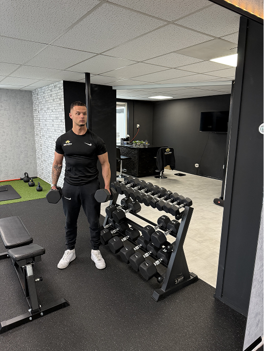 Een trainer met dumbbells in de Welles PT-studio