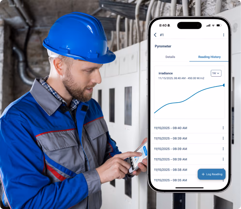 Worker in a blue uniform and helmet checks irradiance readings on a smartphone with a graph overlay.