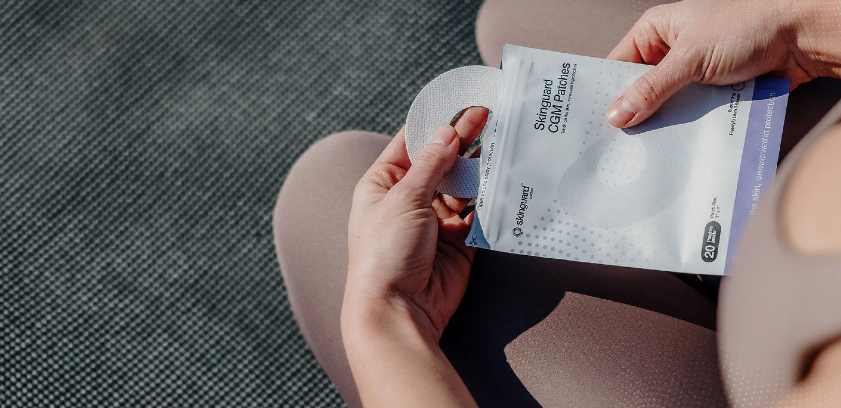 A person holds a packet of skin care products, taking out a circular pad.