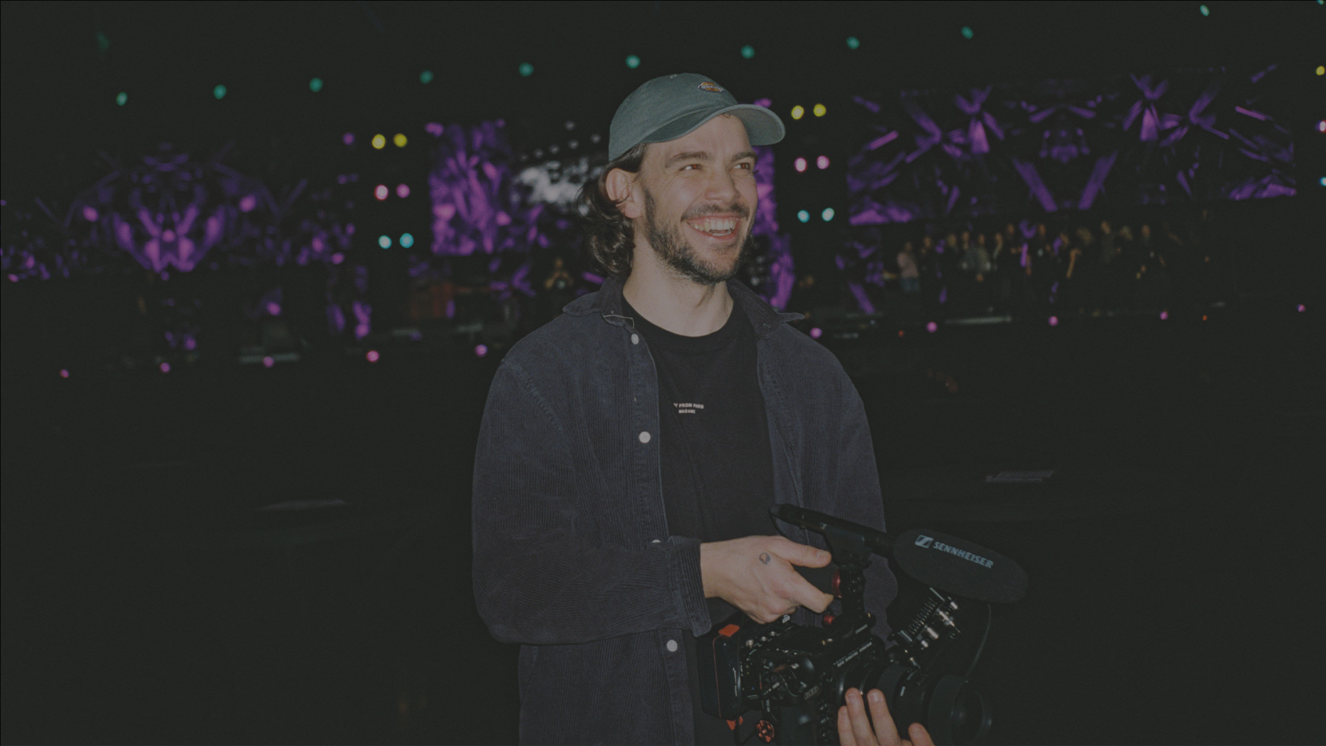 A man with a video camera smiling