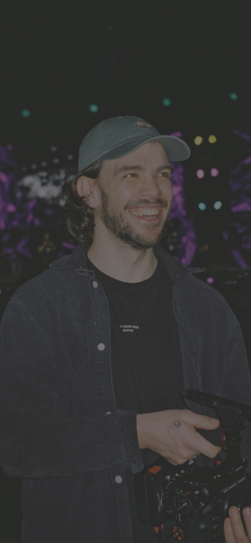 A man with a video camera smiling