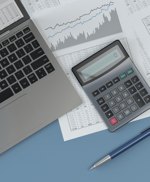 Laptop and calculator sitting on top of papers with charts
