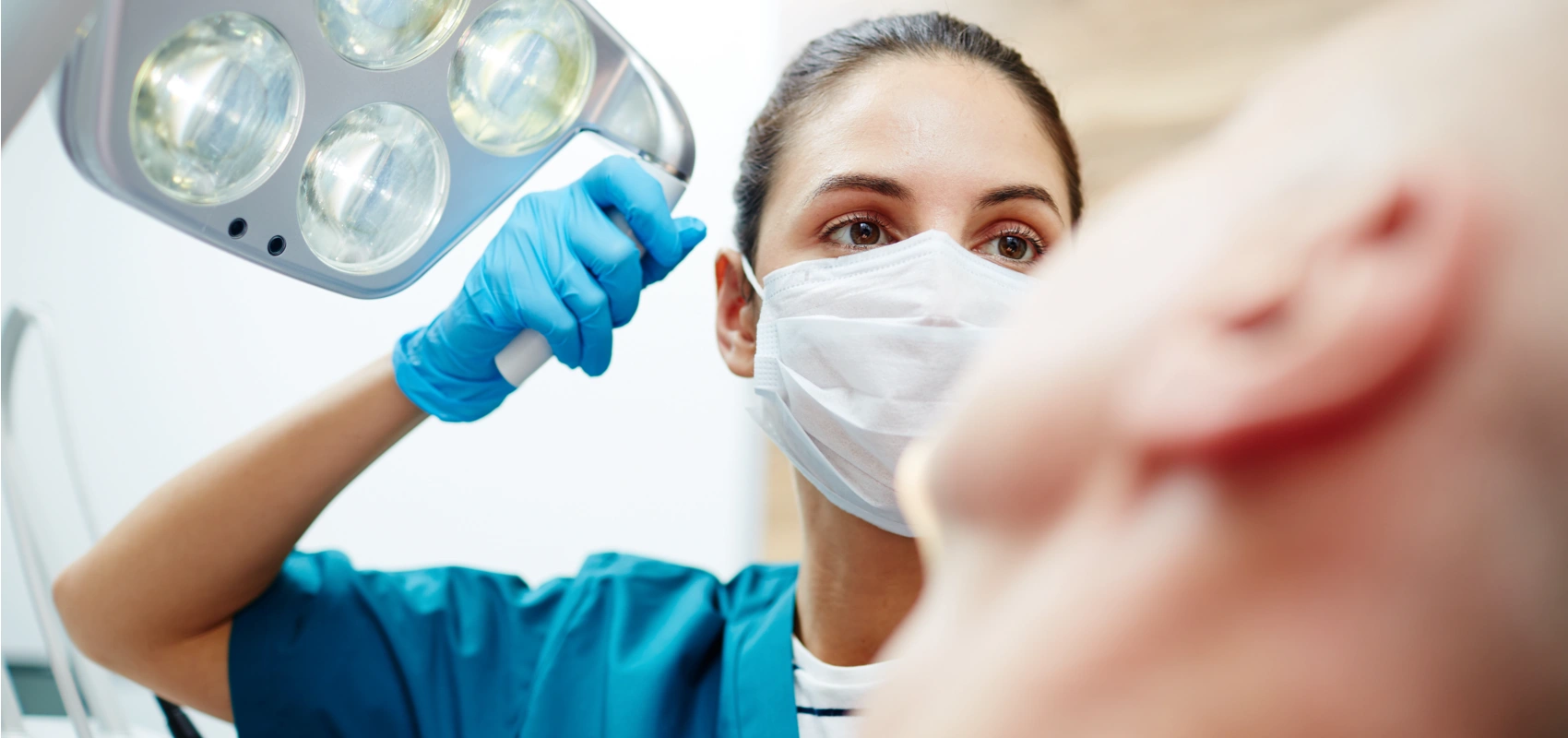 Dentist shining a light into the mouth of a patient