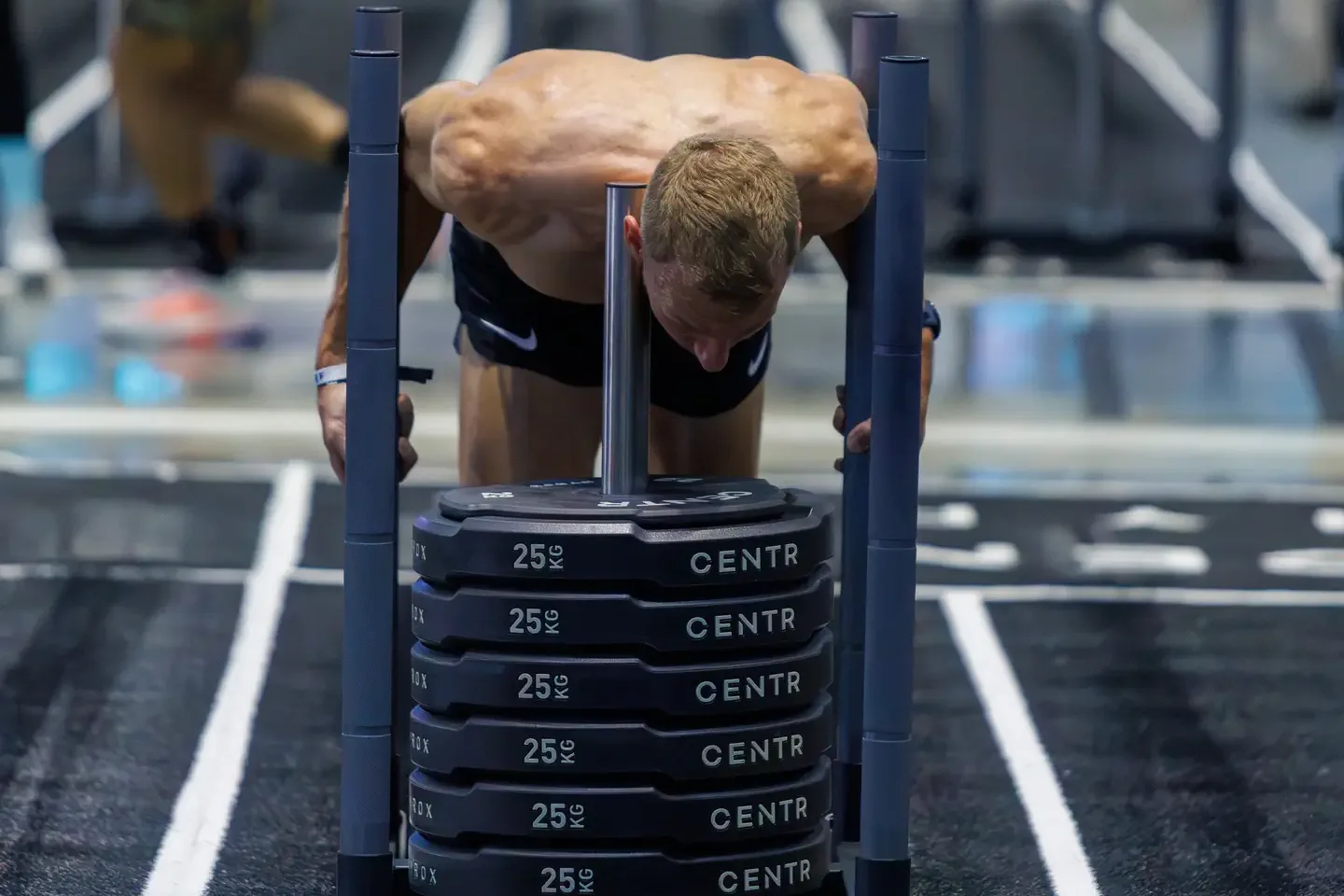Coach Romain Chevalier pushing the sled at HYROX Bangkok 2026
