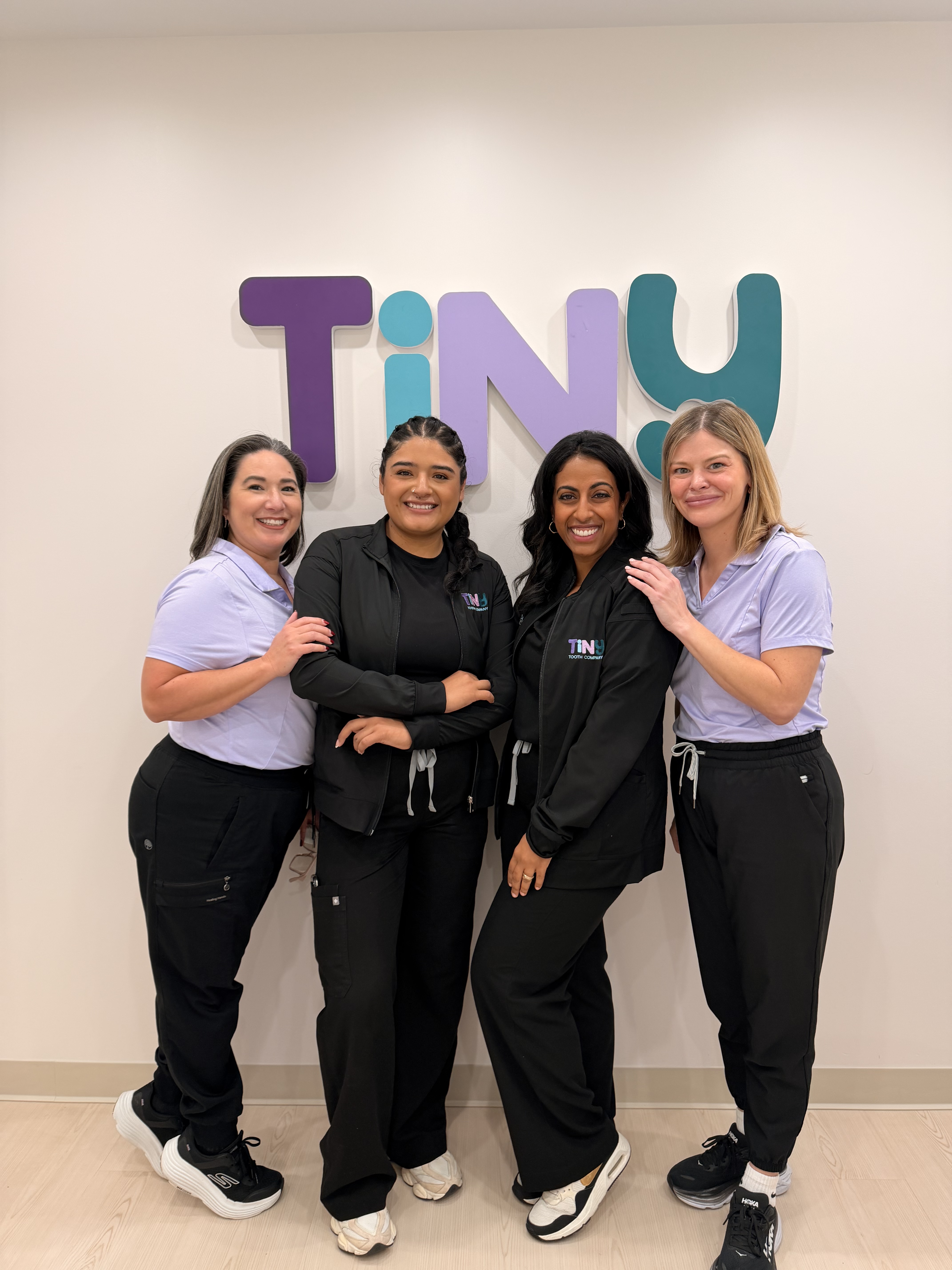 Friendly Tiny Dental Company team of pediatric dentists, hygienists, and support staff gathered together, welcoming families to their pediatric dental practice in The Woodlands, TX