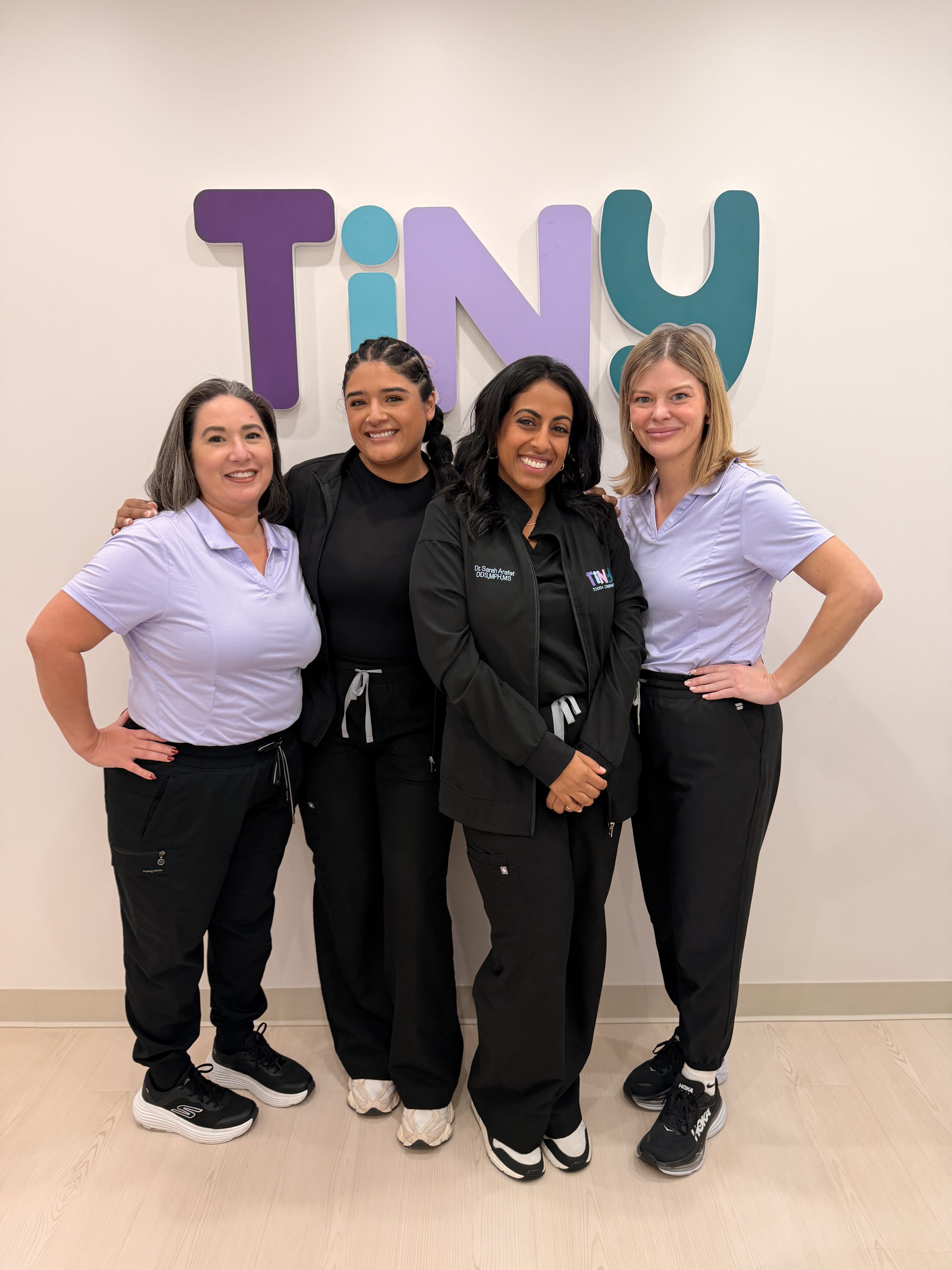 Friendly Tiny Dental Company team of pediatric dentists, hygienists, and support staff gathered together, welcoming families to their pediatric dental practice in The Woodlands, TX