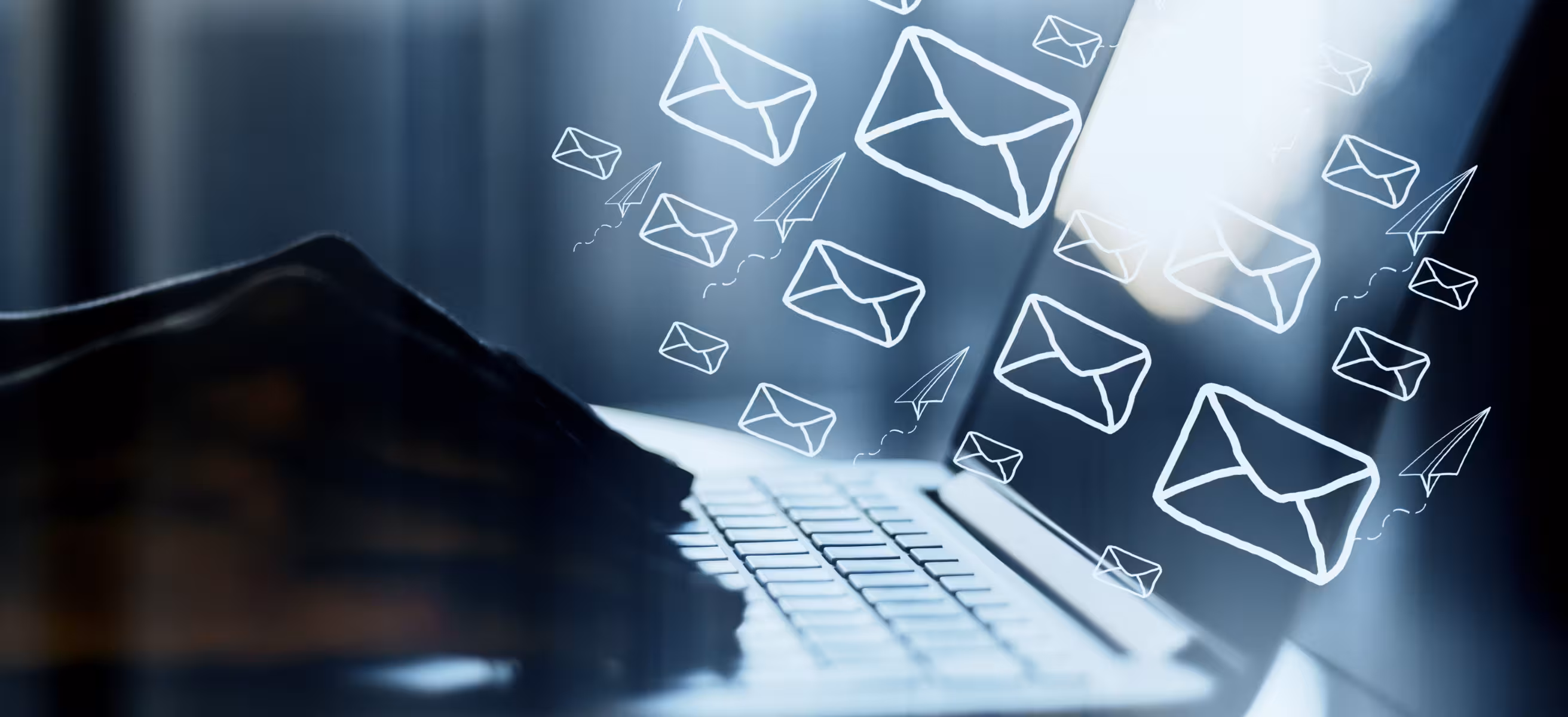 Side view of hands using laptop on desktop with digital emails on blurry background. Email network and communication concept. Double exposure.