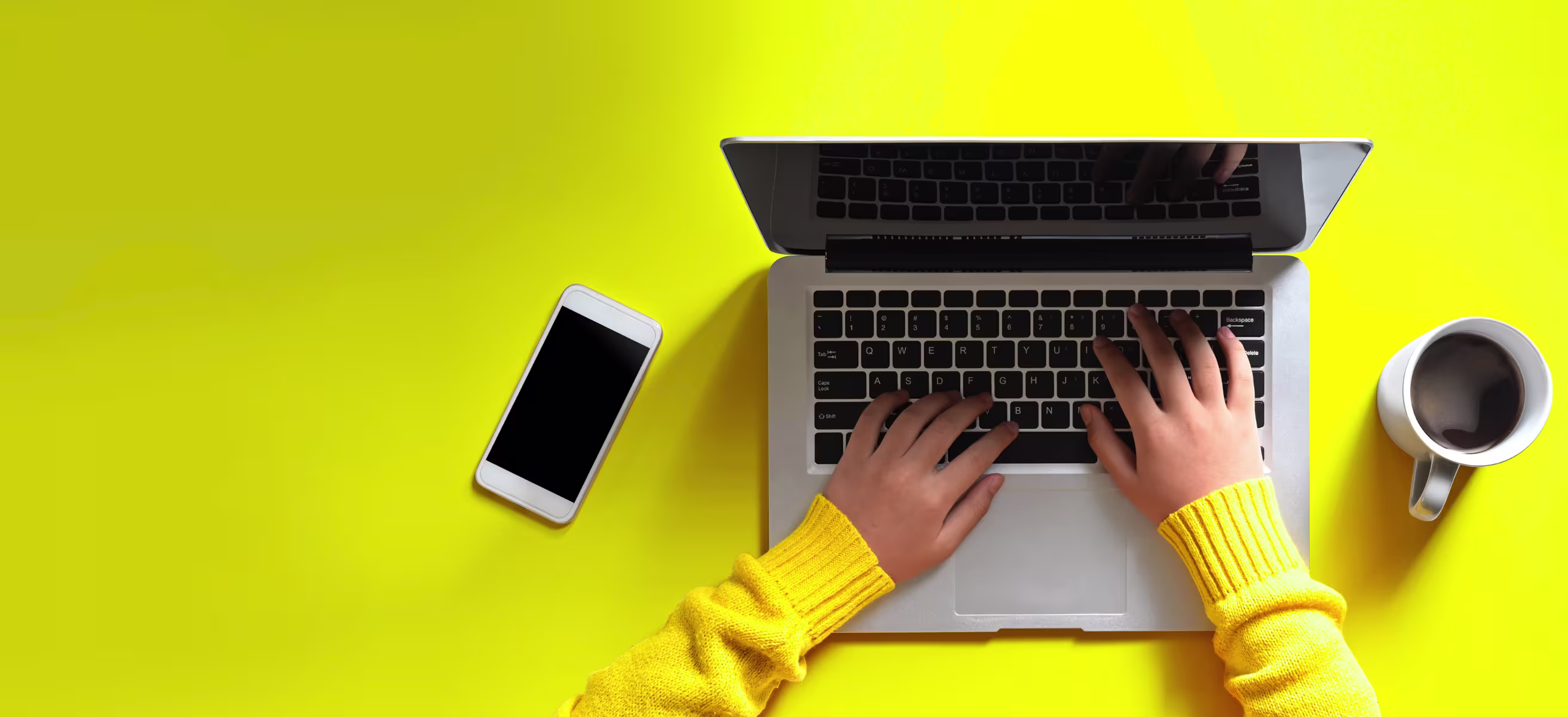 A person typing on a laptop against a bright yellow background, illustrating plug&plays outbound trends.