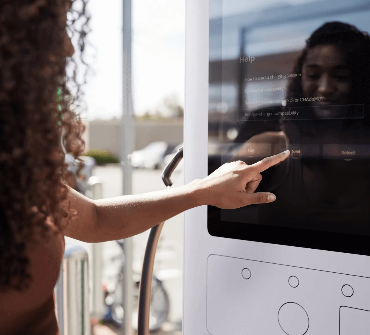 A women is manually operation Electric Era charging points to charge her EV
