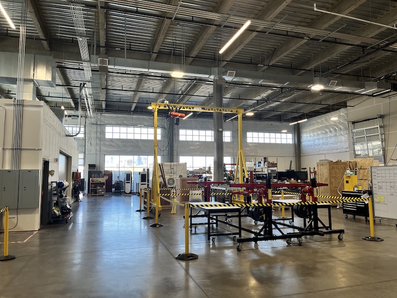 Assembly floor with gantry crane and workbenches where charger and battery units are tested