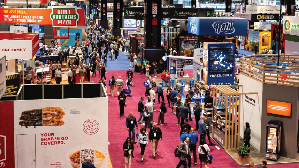Overhead view of the NACS Show exhibit hall packed with attendees and exhibitor stands.