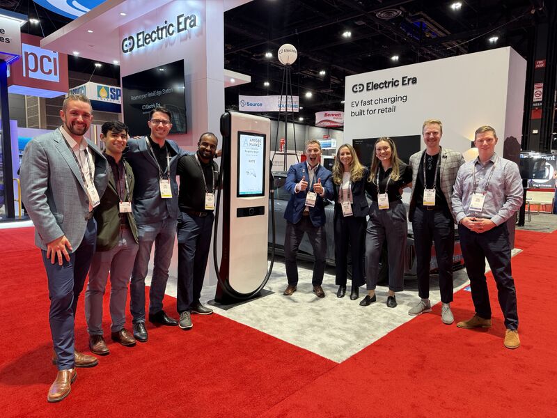The Electric Era team standing together at their NACS Show booth.