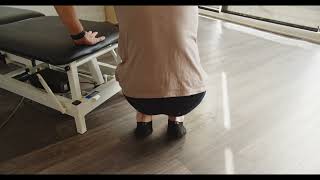 Physio démontrant mobilité des genoux accroupi