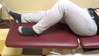 Physio démontrant flexion du genou et de la hanche couché