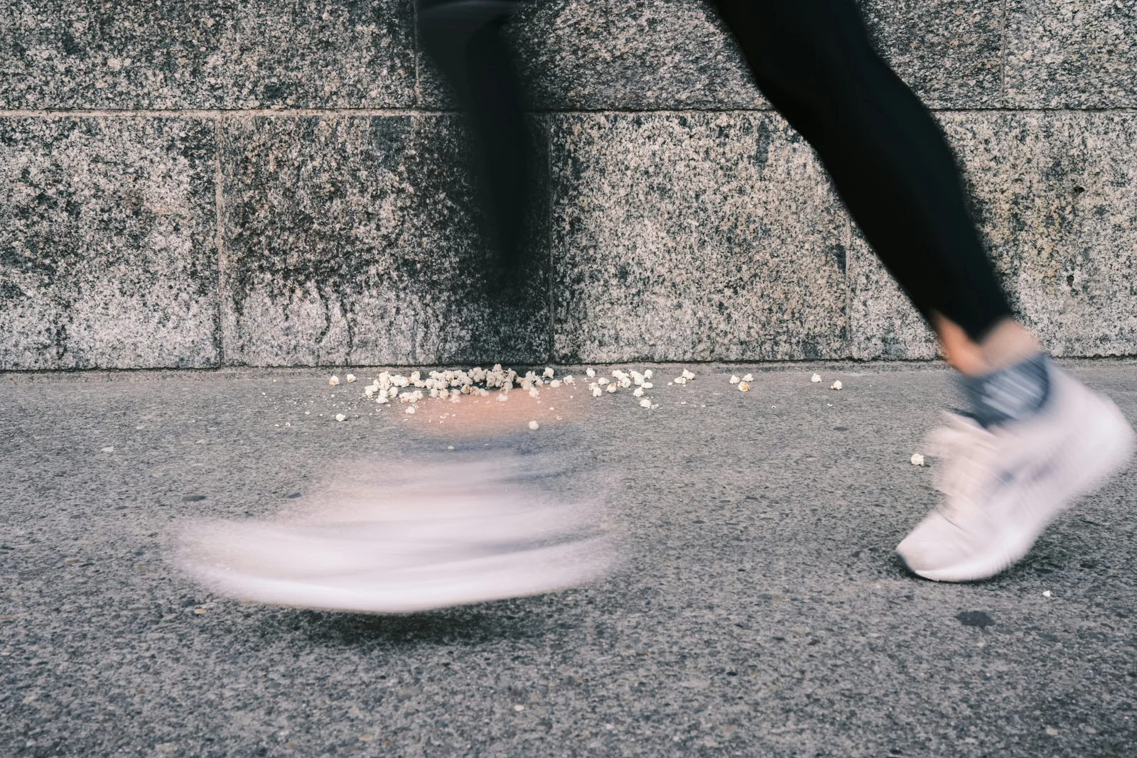 A runner in motion wearing white running shoes on the sidewalk; a case study analyzed in physical therapy