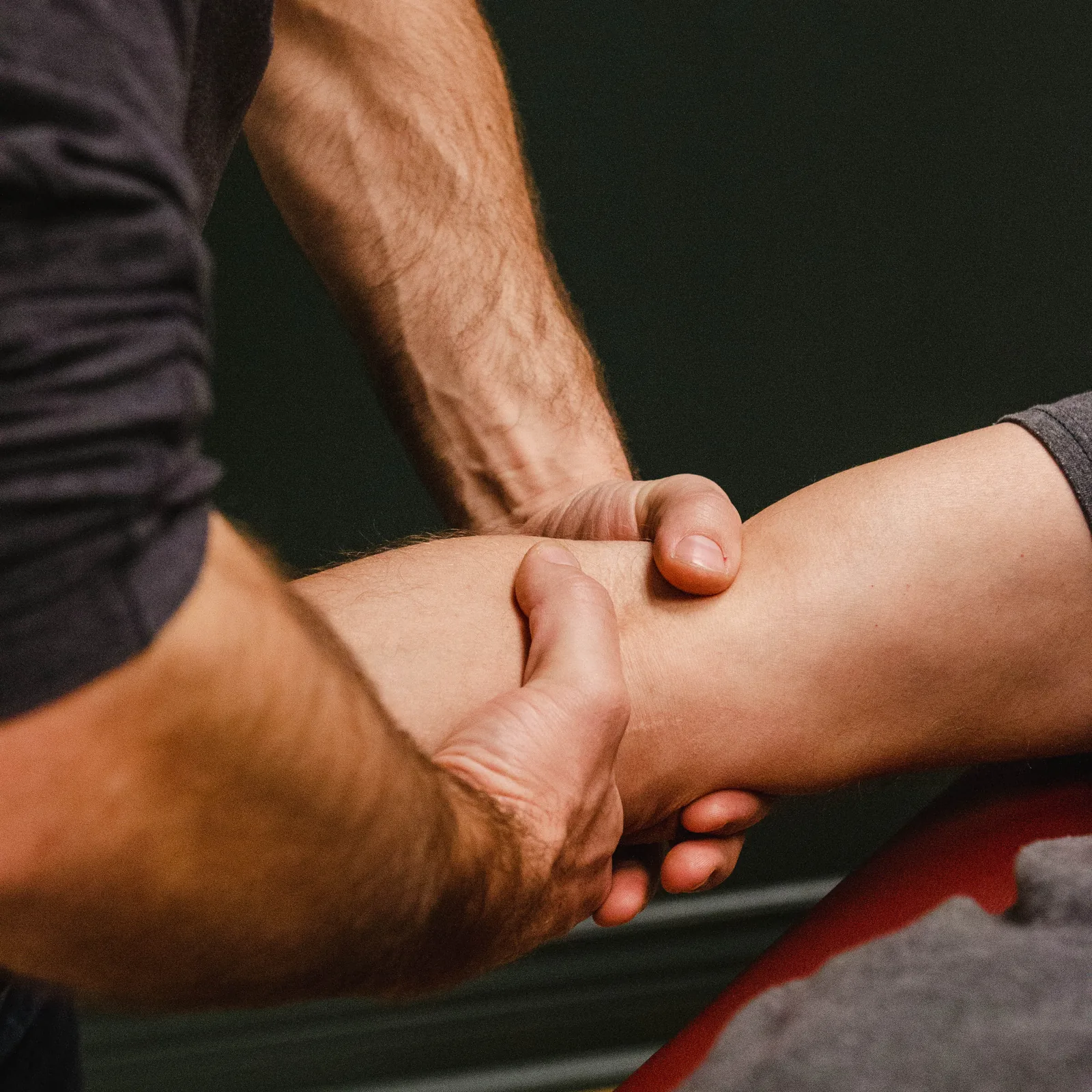 Physiothérapeute Physioactif effectuant un traitement manuel du coude d'un patient en physiothérapie