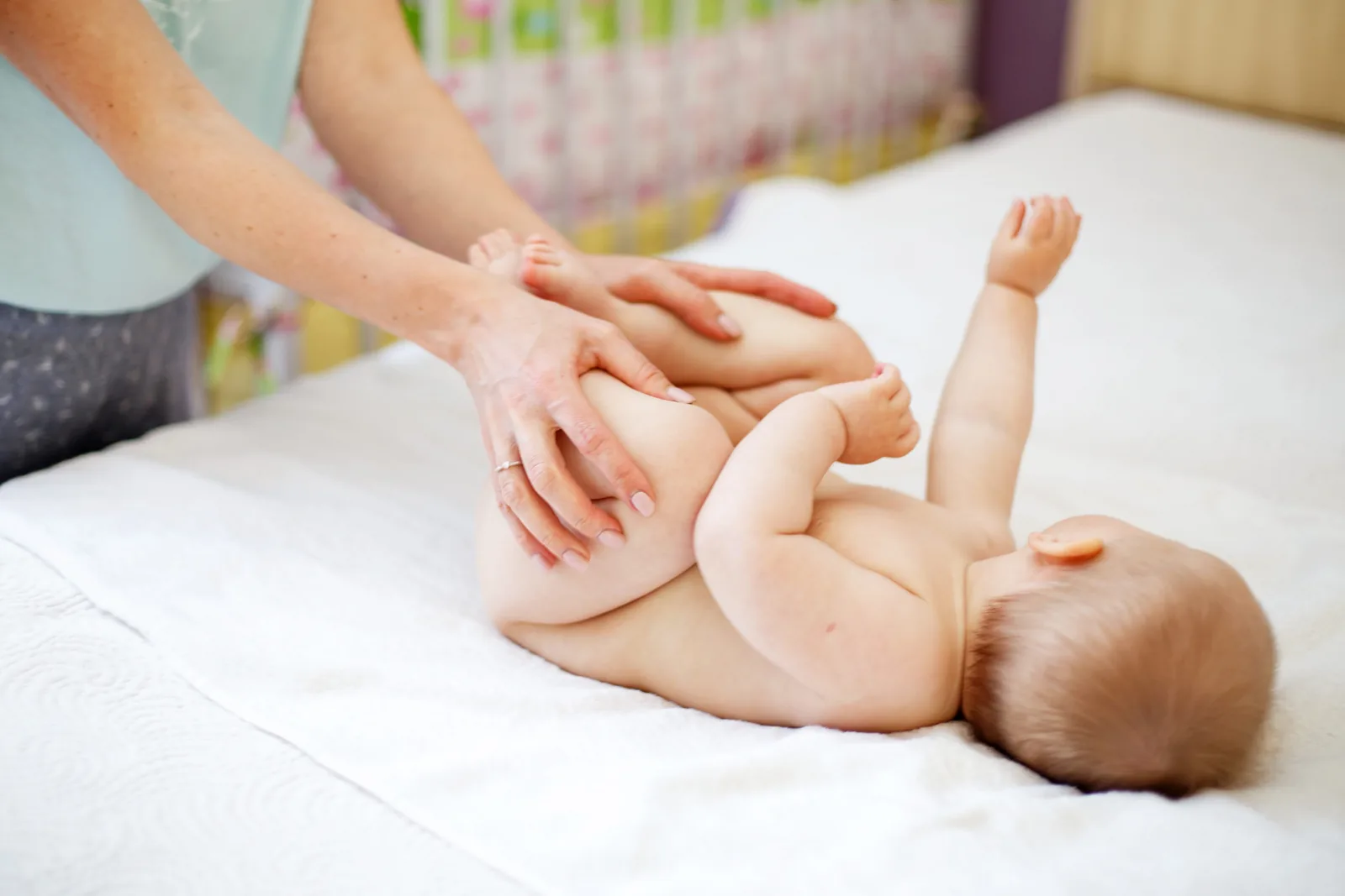 Physiothérapeute mobilisant les jambes d'un bébé en pédiatrie, soins de physiothérapie Physioactif