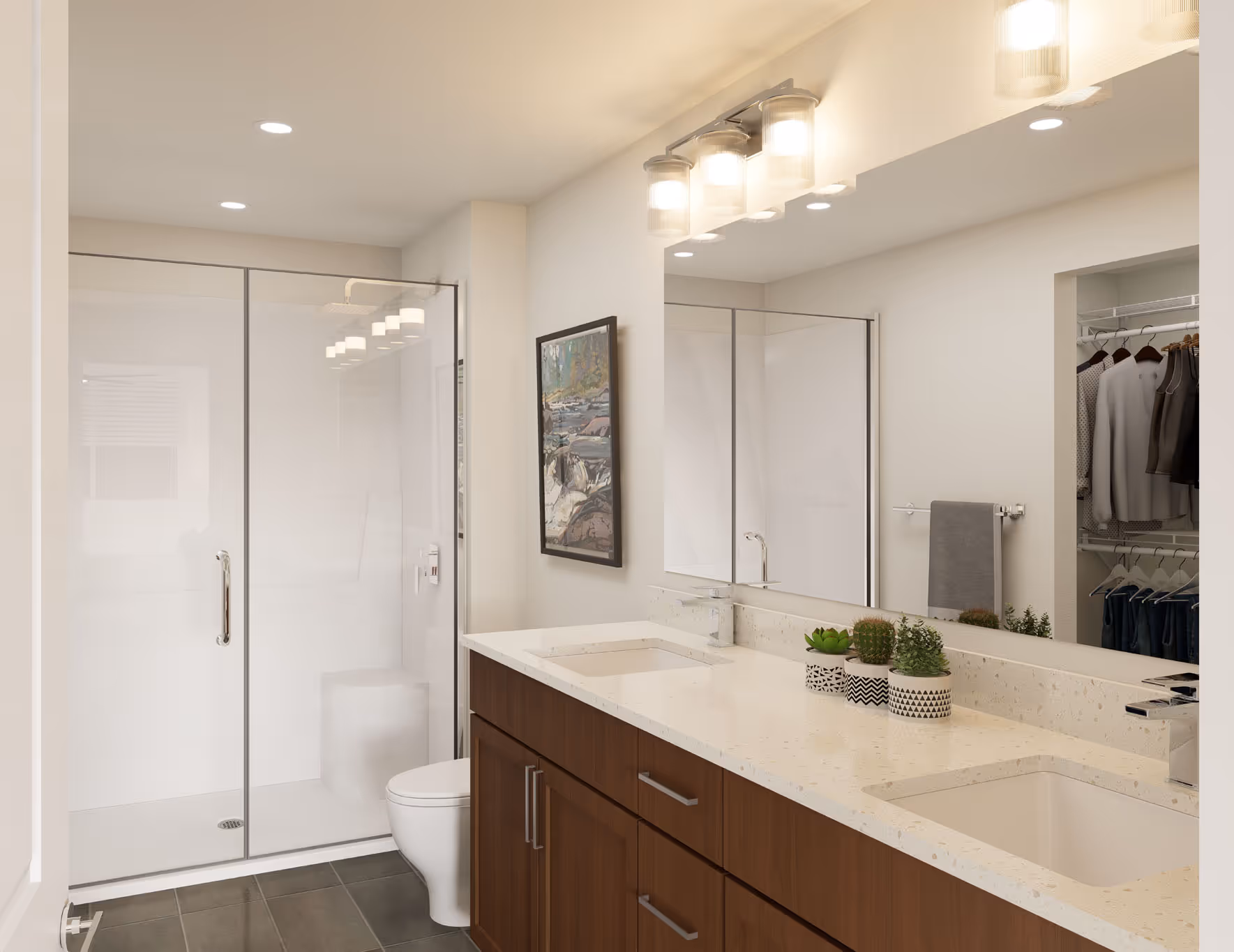 Modern bathroom with a double vanity, dark wood cabinets, a walk-in glass shower, and a large mirror at Avondale Commons in Avondale, AZ.