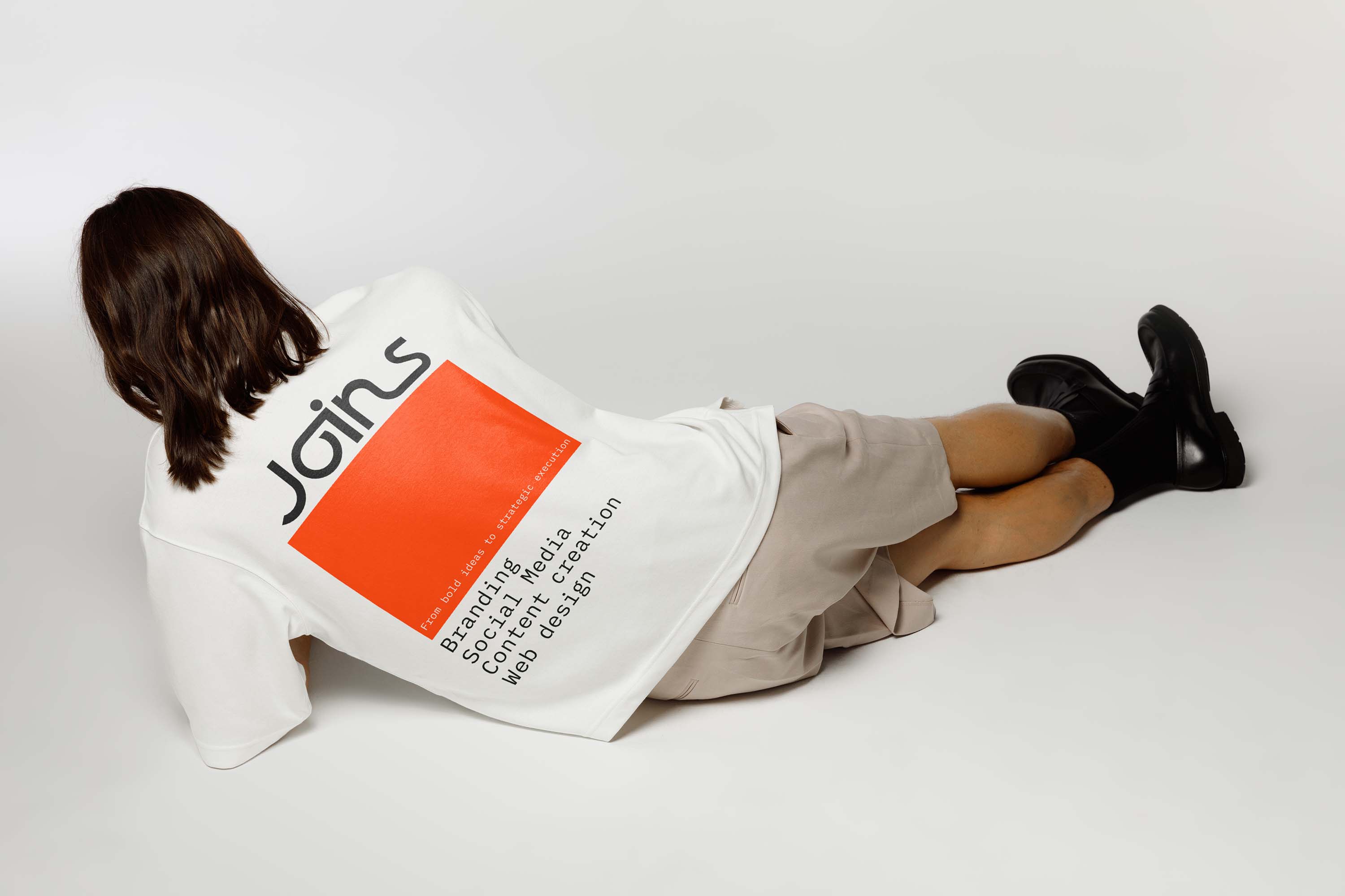 Girls wearing a swater with the logo of Joins on the back