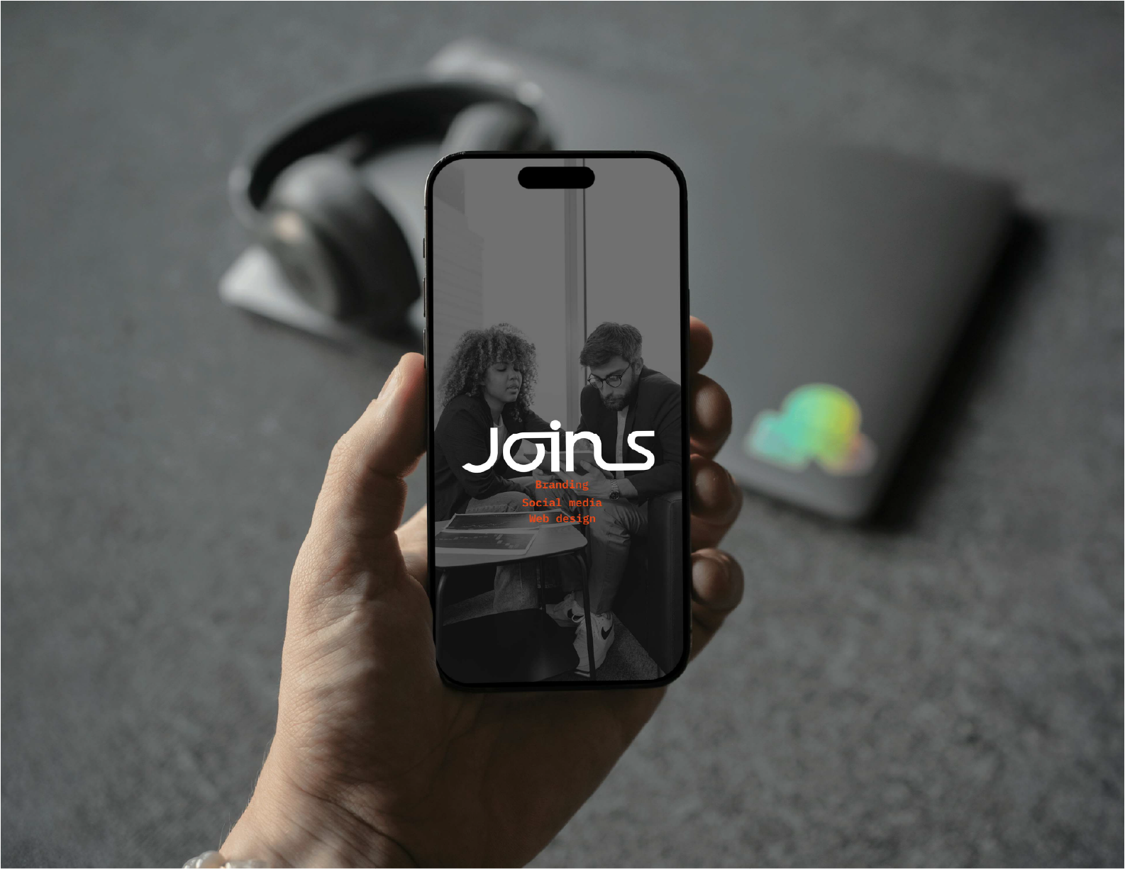 Phone held by young people with a Joins background