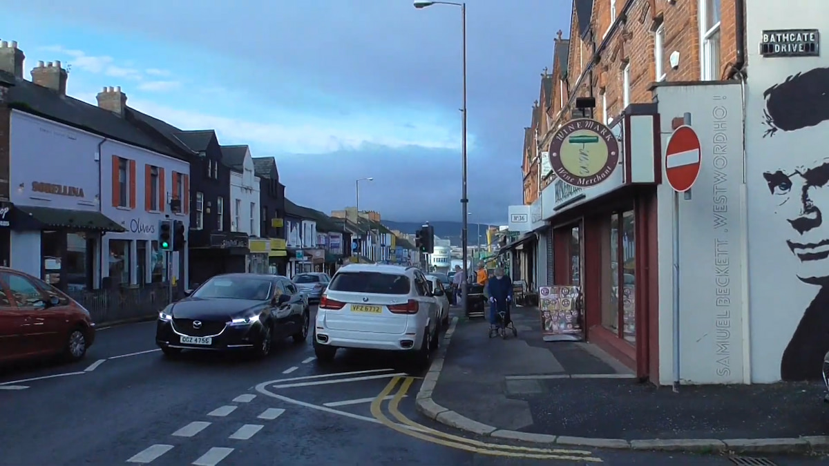 Street-level view of Belmont Road, featuring Oliver’s Coffee and nearby shops along the bustling street.
