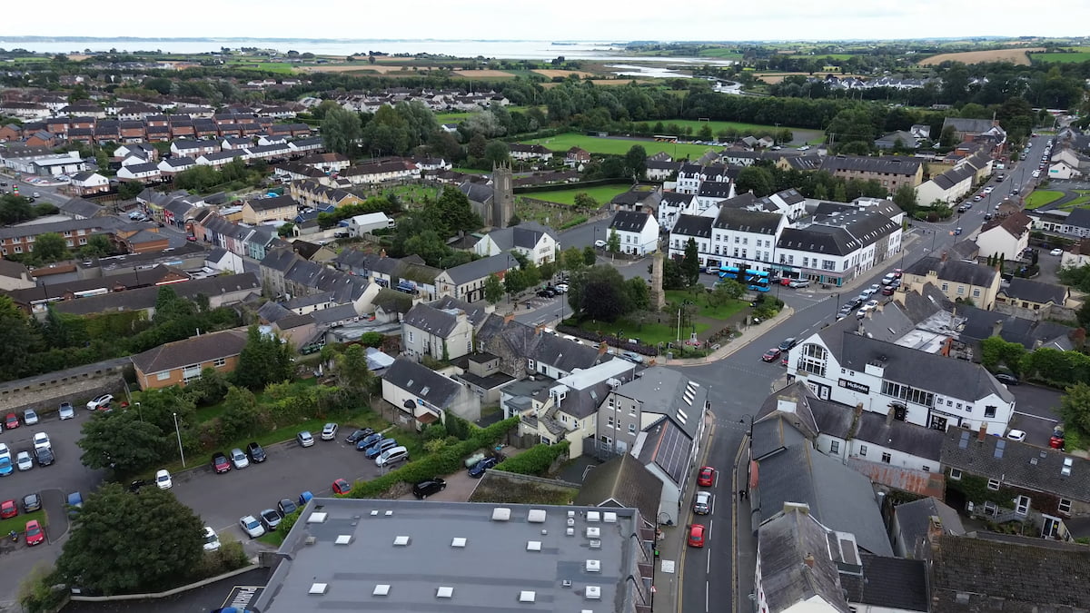 View over Comber, featuring a mix of residential homes, town center buildings, and surrounding countryside.