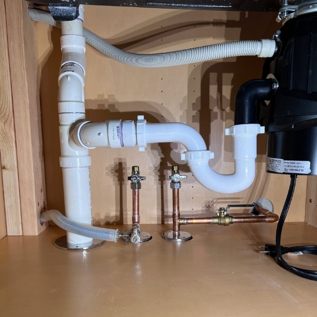 Under kitchen sink plumbing with garbage disposal