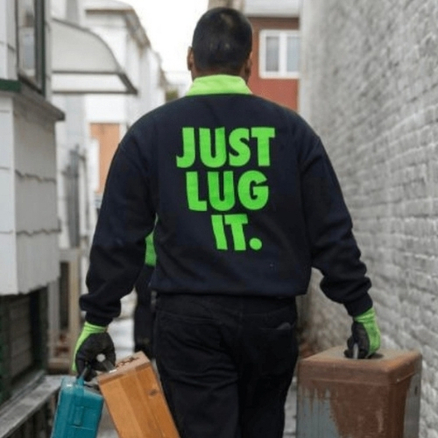 Junkluggers employee wearing a sweatshirt that says "Just Lug It"