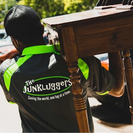 Junkluggers employee carrying a table