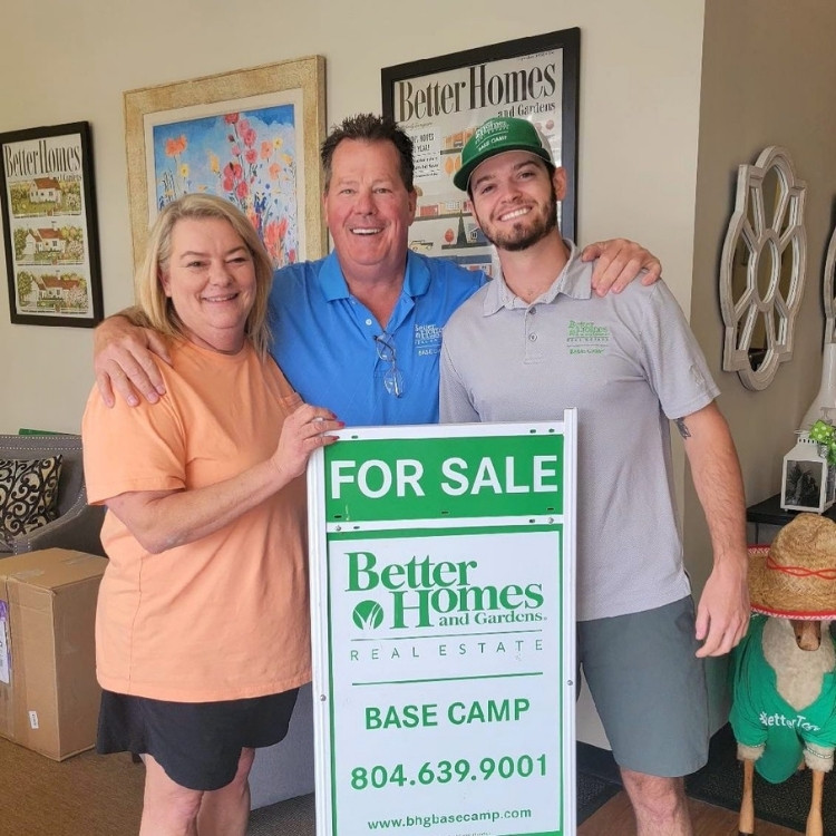 Cody Adams in front of For Sale sign with clients