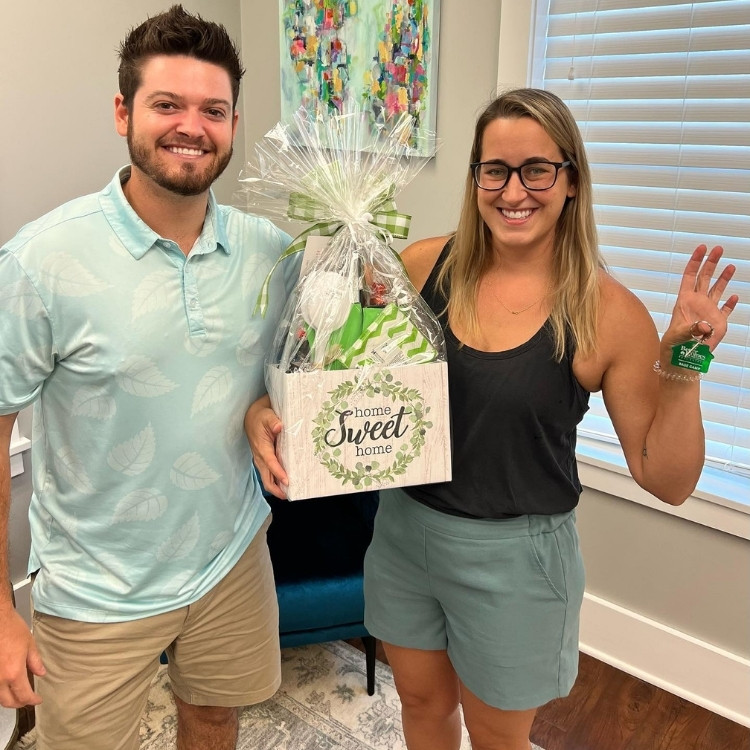 Cody Adams with happy client and gift at closing