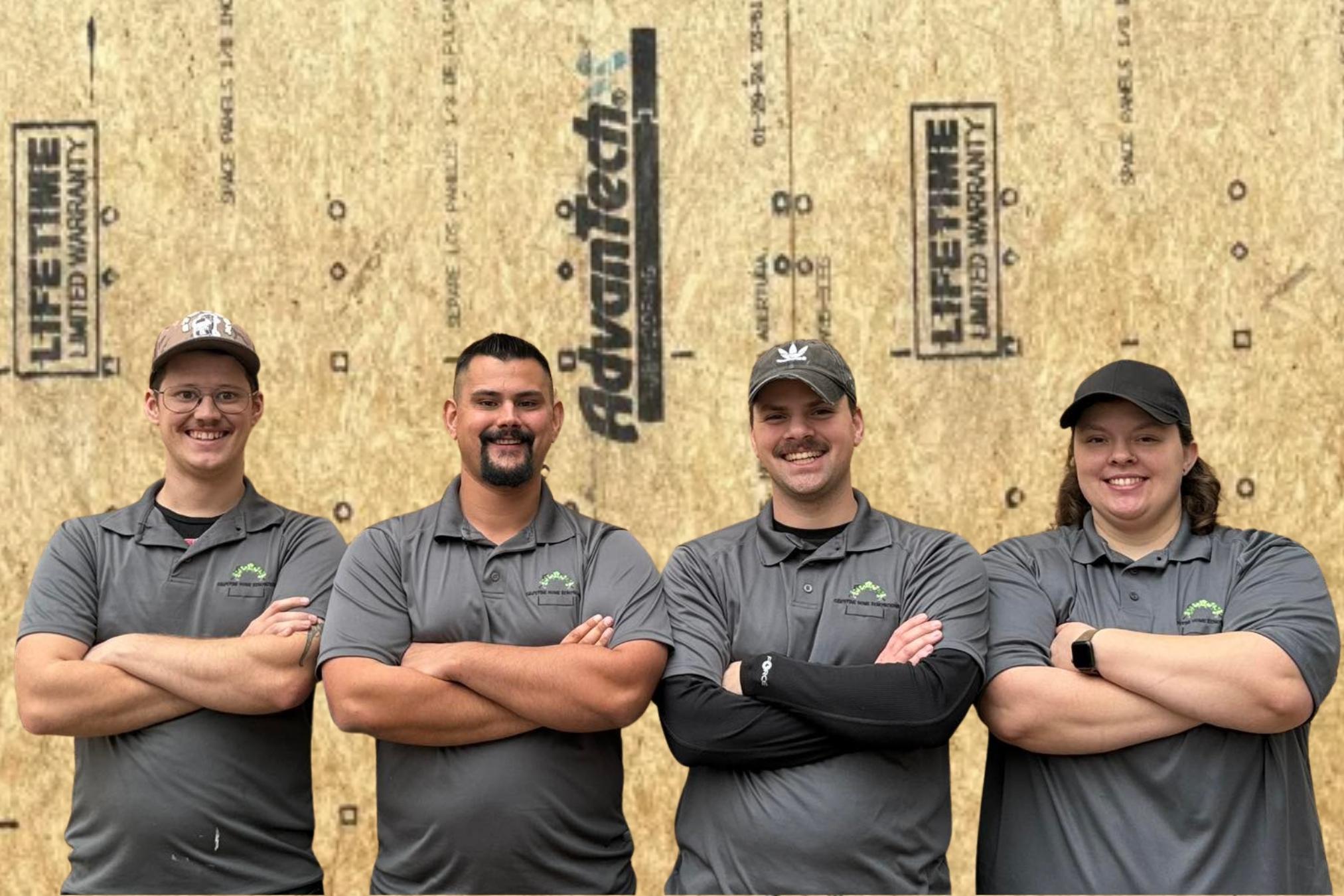 4 contractors standing in front of plywood
