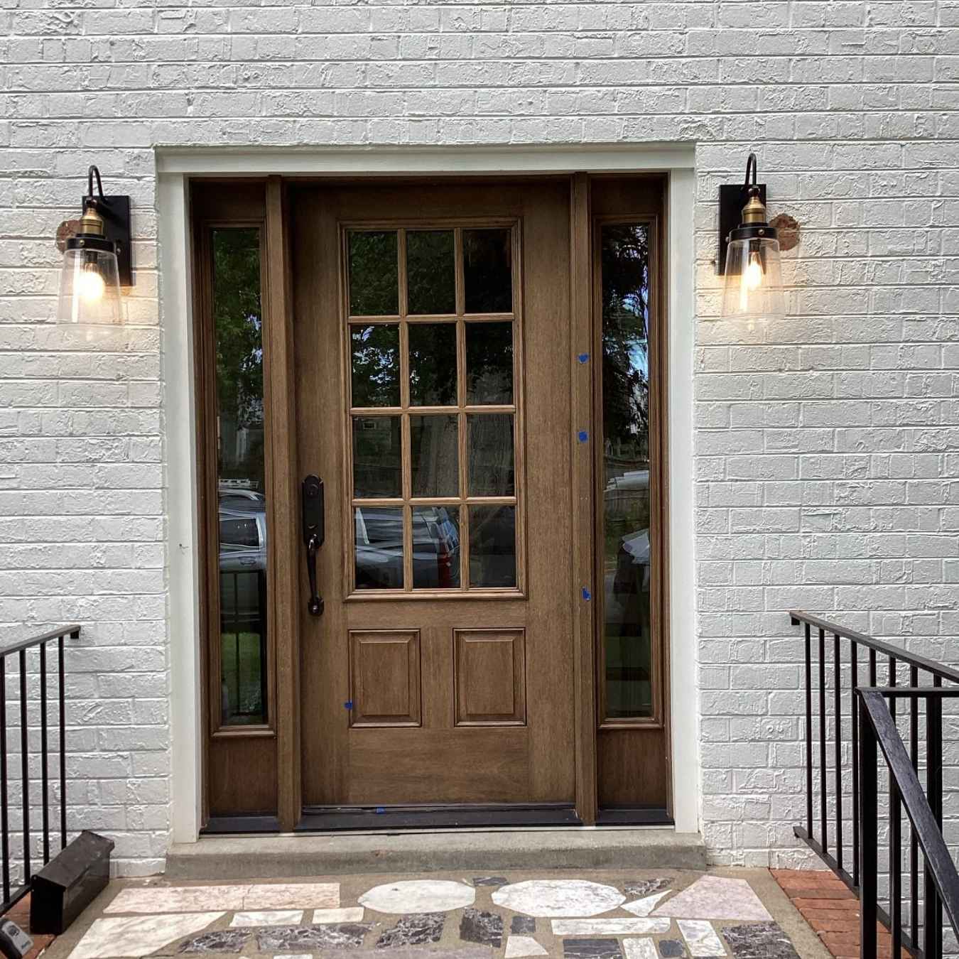 Outdoor lighting fixtures flanking a wooden door