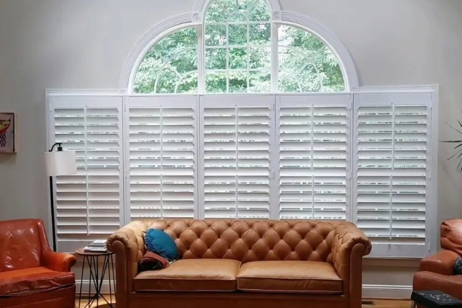 plantation shutters behind a leather couch