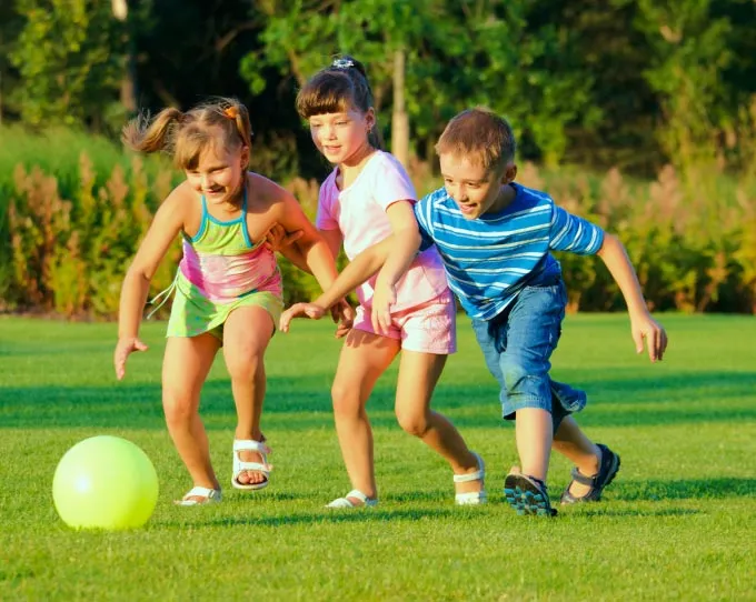 kids playing soccer in yard