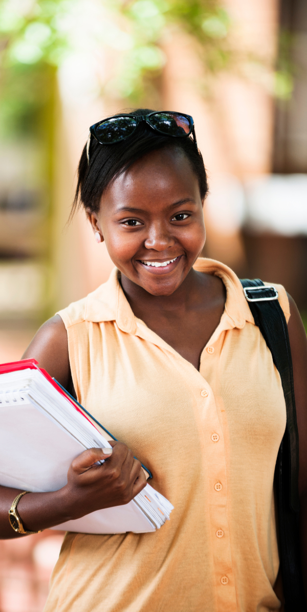Smiling woman studying with notes, representing focused ACT and SAT prep through structured, targeted strategies